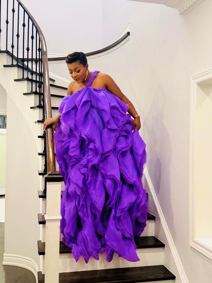 Royal purple tiered organza ruffle gown on a curved staircase